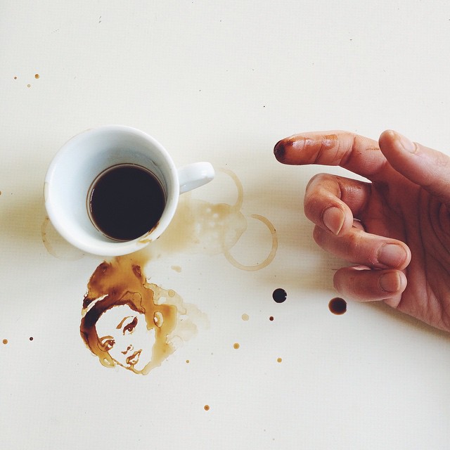 A hand crafting a portrait using spilled coffee