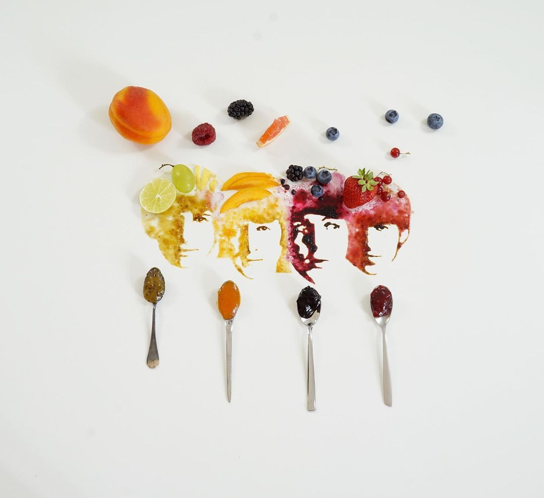 Artistic representation of faces using fruit spreads and fresh fruits.