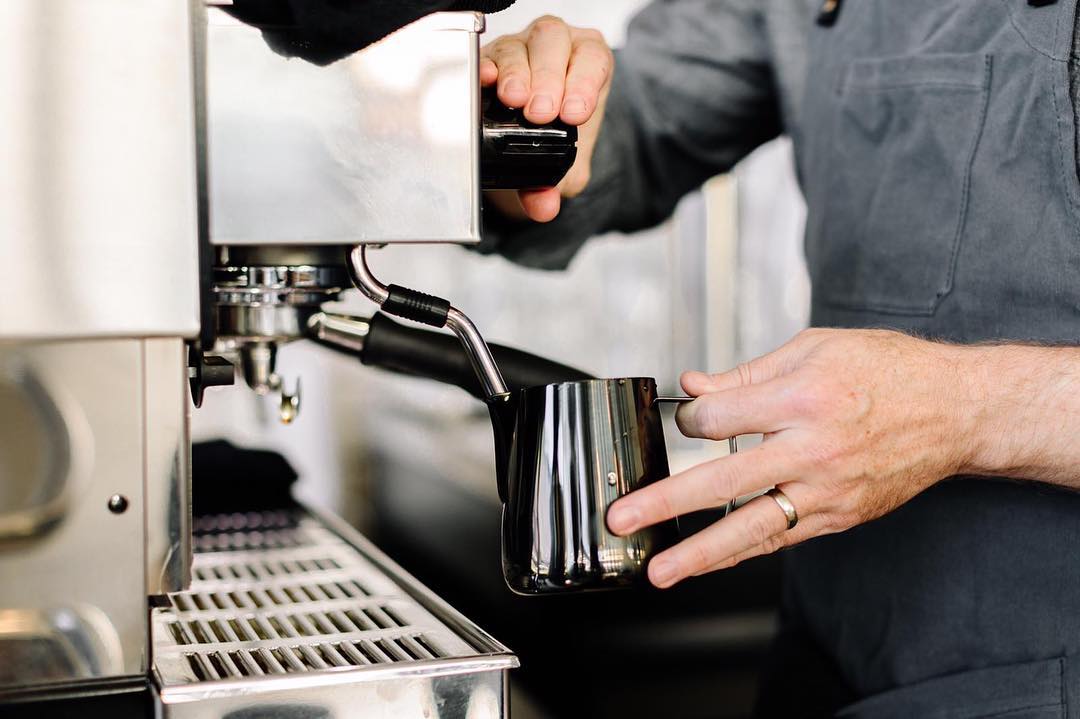 Barista preparing coffee with professional espresso machine