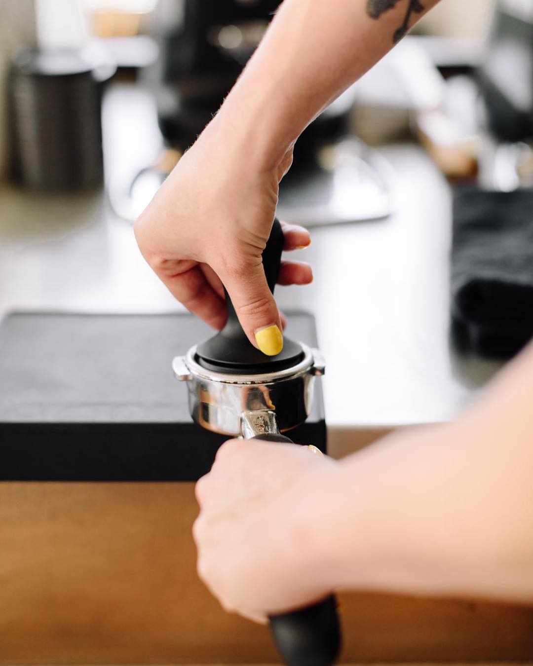 Barista tamping coffee grounds