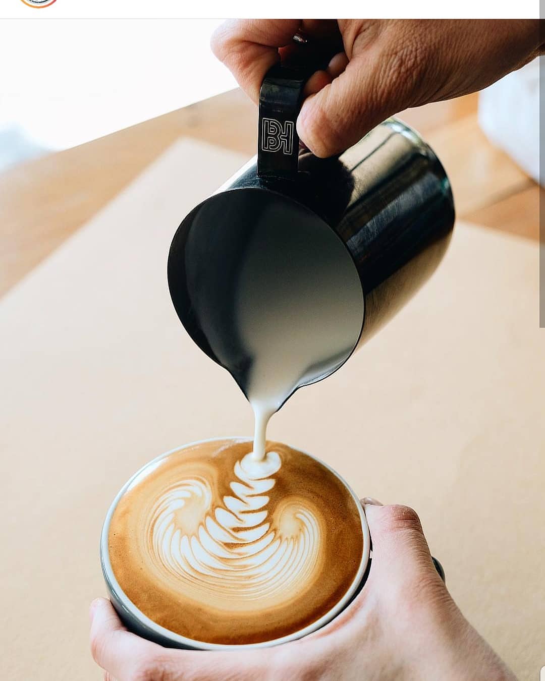 A skilled barista creating intricate latte art in a cup of coffee