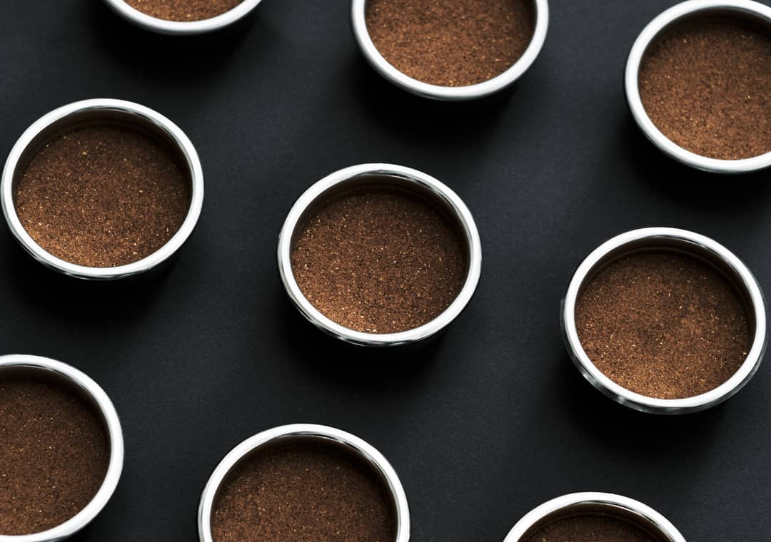 Neatly arranged coffee pods on a dark background