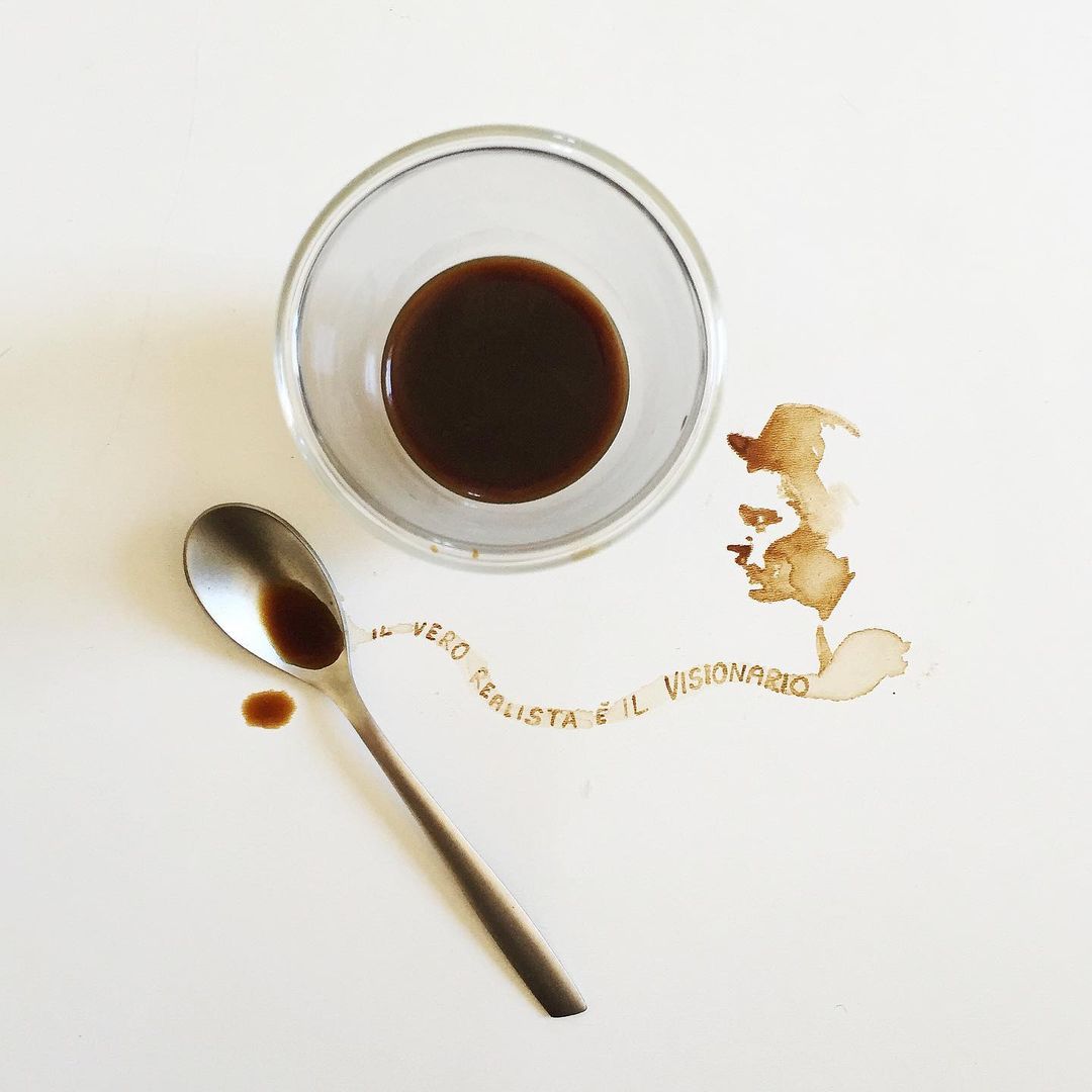 An artistic arrangement of a coffee cup with remnants, a spoon, and coffee stains on a surface.