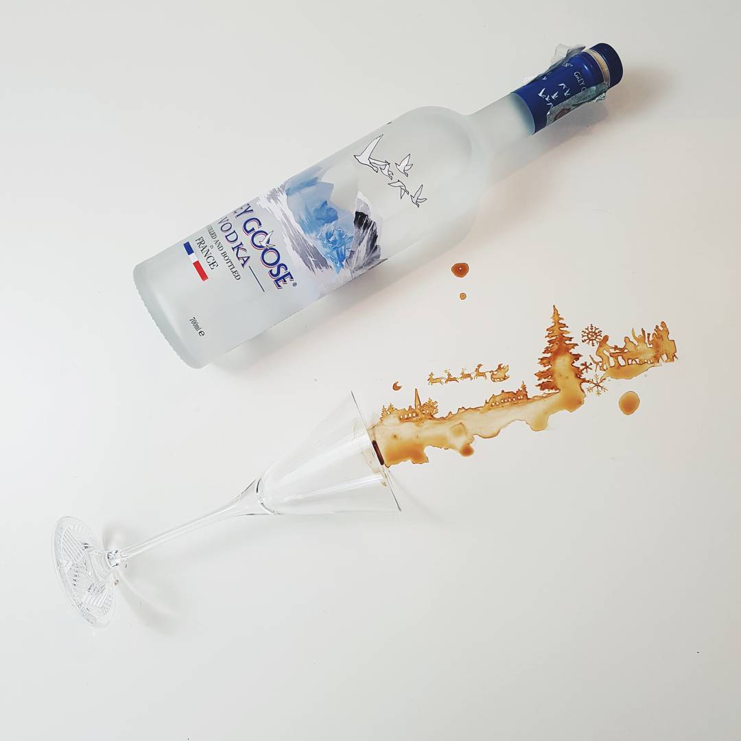 An artistic arrangement of a tipped vodka bottle and a spilling glass creating a landscape scene