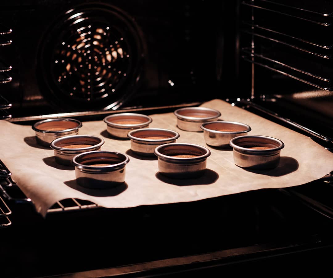 Ramekins of chocolate dessert baking in an oven