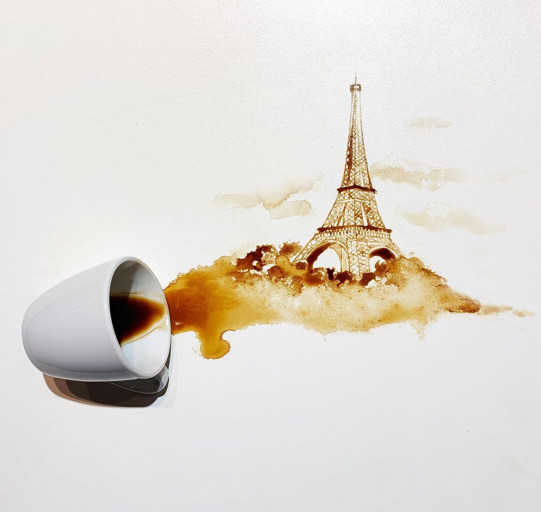 A spilled cup of coffee artistically transforms into an illustration of the Eiffel Tower