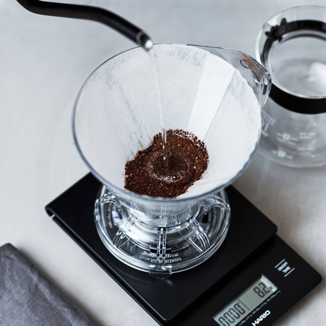 Pouring hot water into a coffee dripper on a digital scale