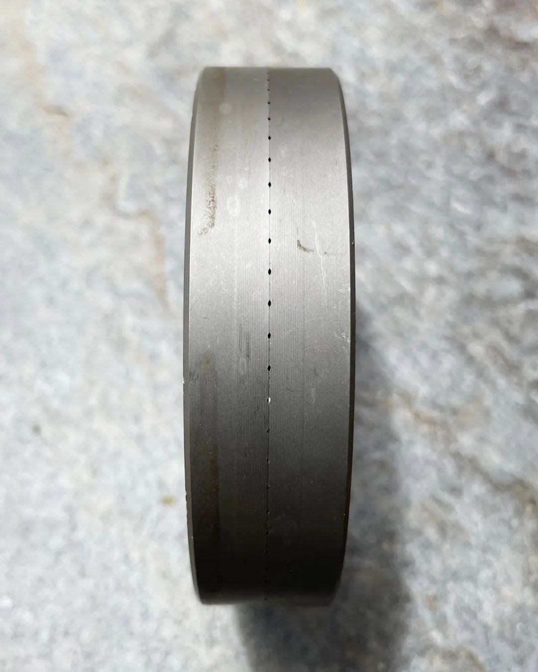 A precision-machined steel ring with fine measurement markings