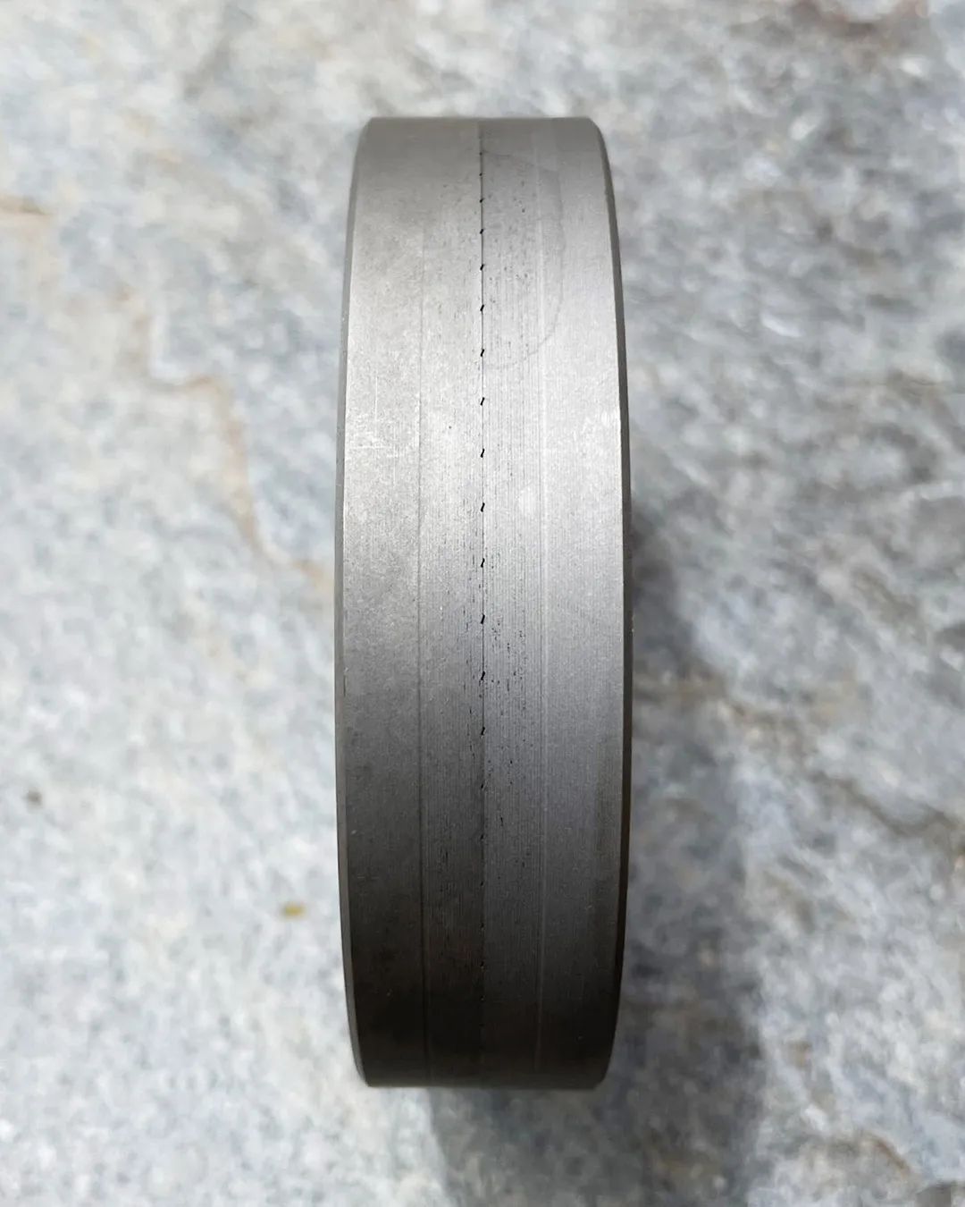 A finely machined steel wheel with precision grooves and a brushed finish