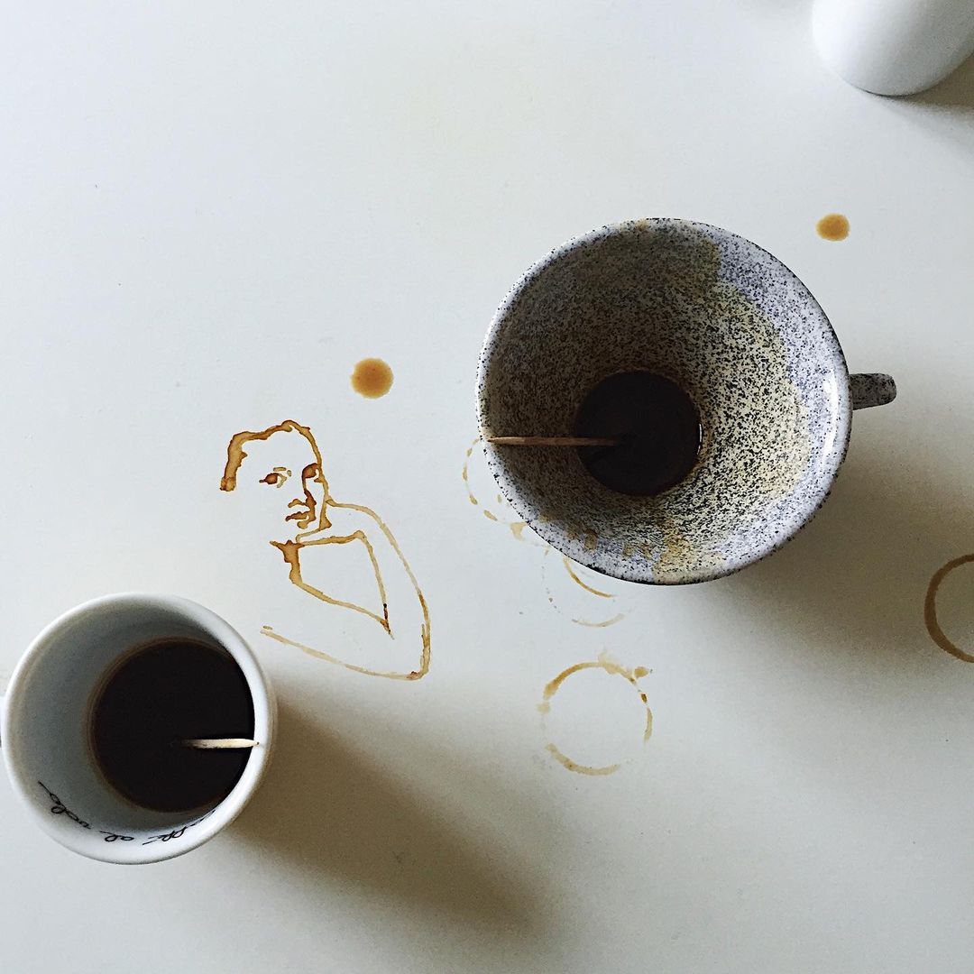 A unique art piece featuring some spilled coffee forming a figure on a white surface